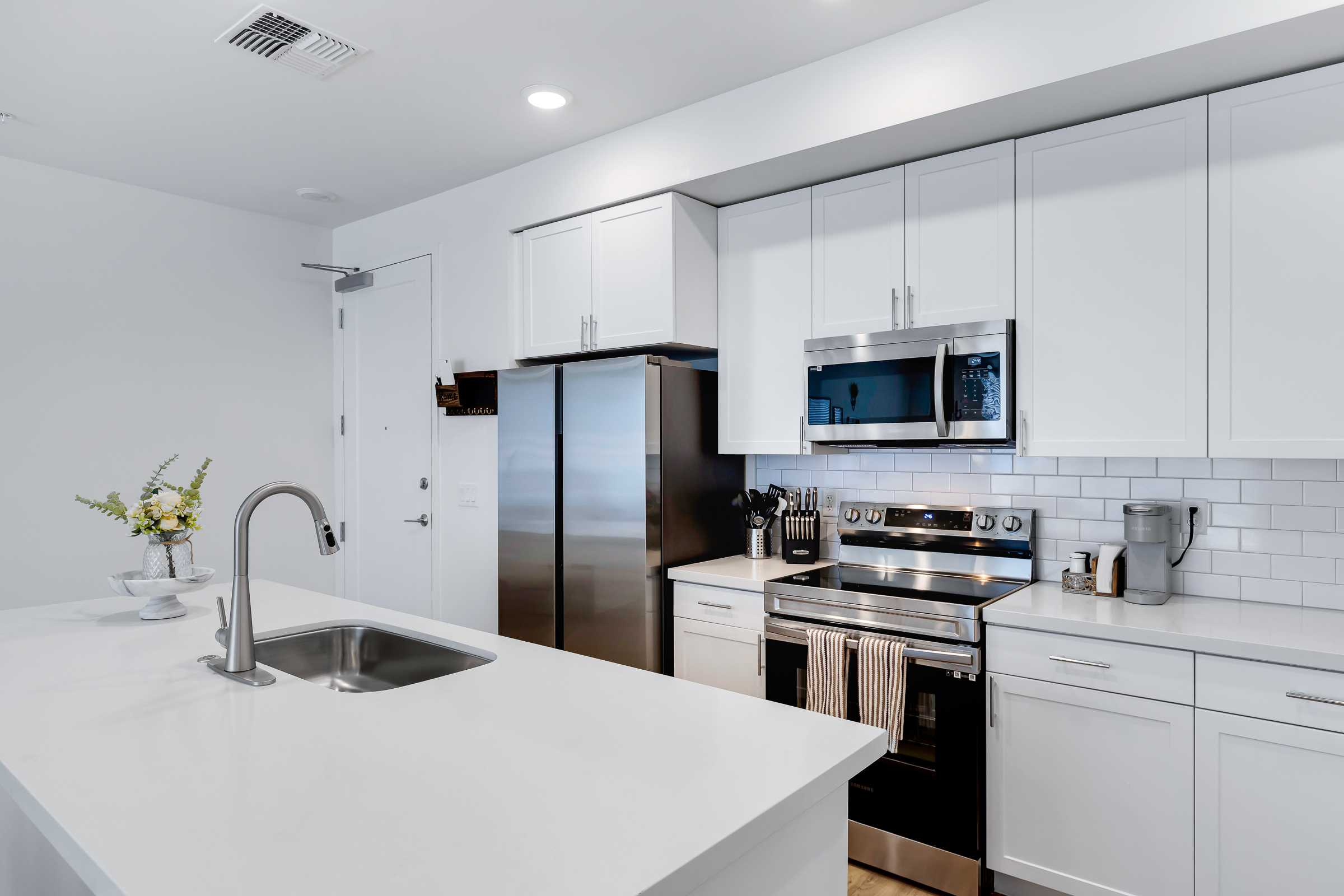 Sleek kitchen featuring stainless steel appliances, white cabinets, and a spacious countertop