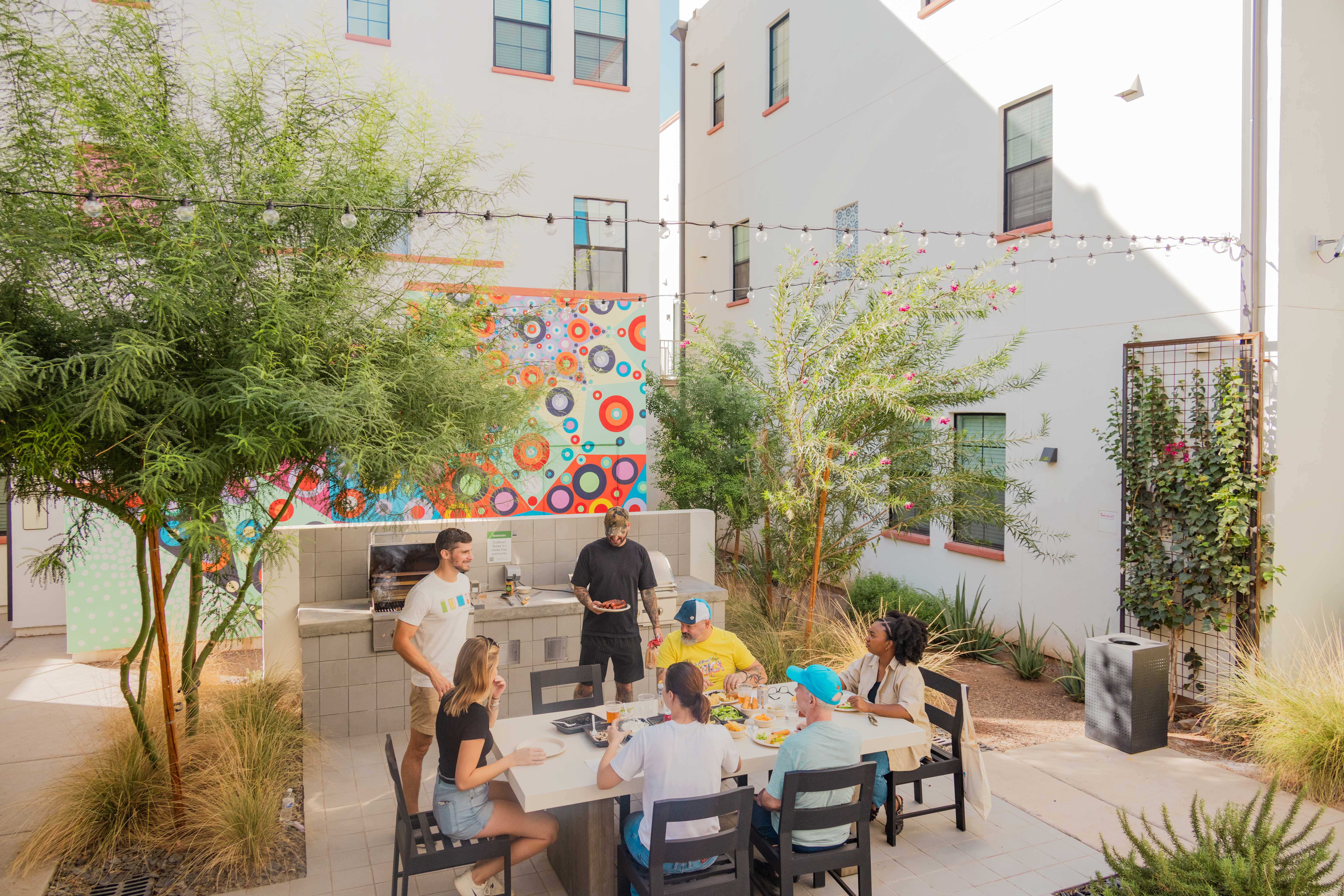 People socializing outdoors around BBQ